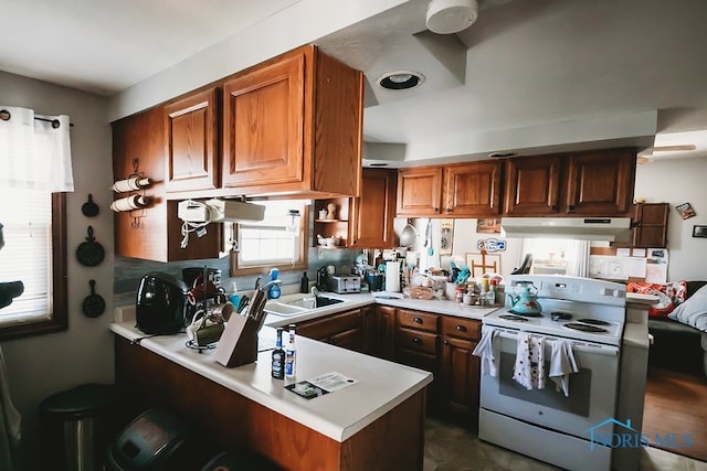 kitchen featuring white electric stove, kitchen peninsula, and a kitchen bar