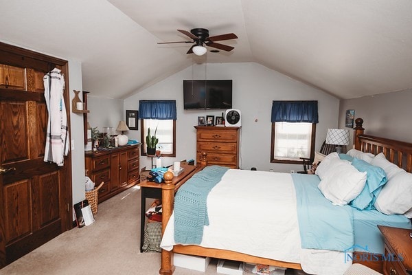 carpeted bedroom with ceiling fan and vaulted ceiling