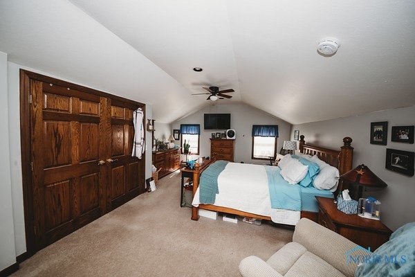 carpeted bedroom featuring lofted ceiling and ceiling fan