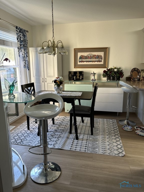 dining space with wood-type flooring and an inviting chandelier