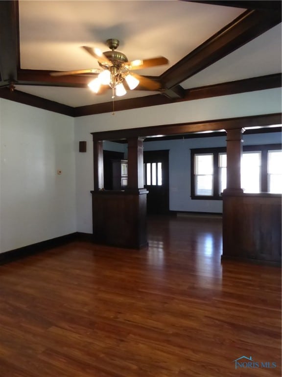 spare room featuring dark hardwood / wood-style flooring, ornate columns, lofted ceiling with beams, and ceiling fan