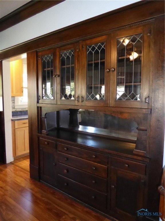 bar featuring hardwood / wood-style flooring and backsplash