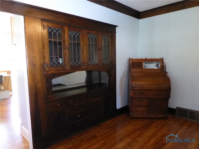 interior space featuring crown molding and dark hardwood / wood-style flooring