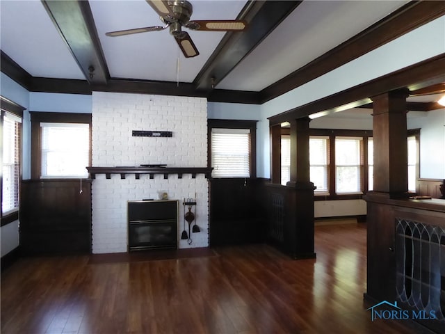 unfurnished living room with dark hardwood / wood-style floors, plenty of natural light, and ornate columns