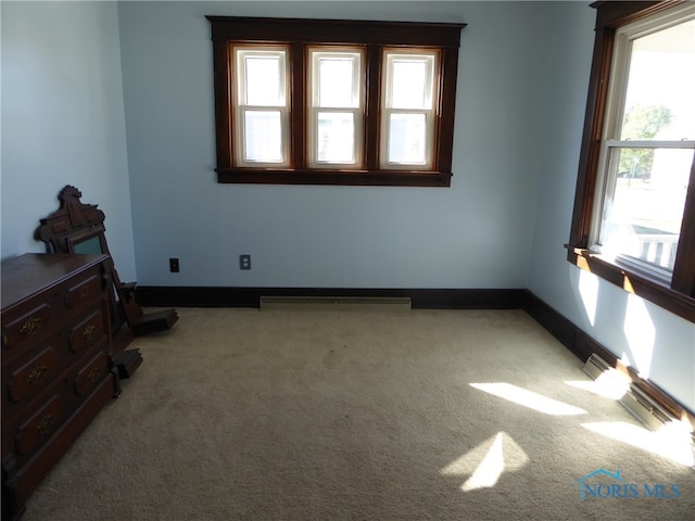 carpeted spare room featuring plenty of natural light