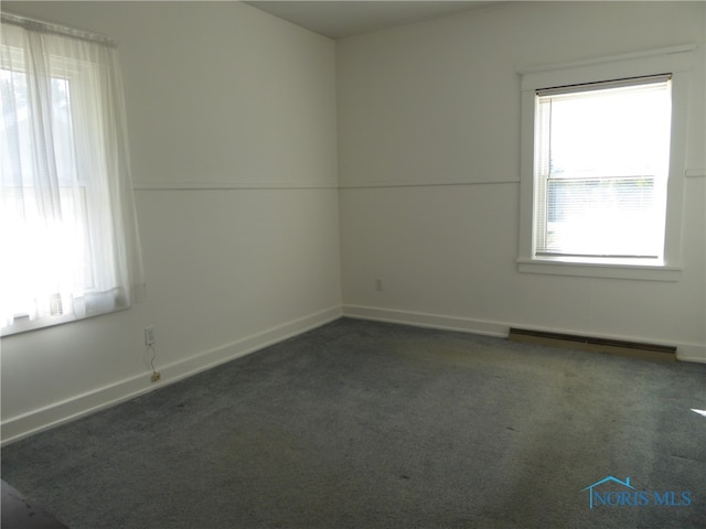 spare room with dark carpet