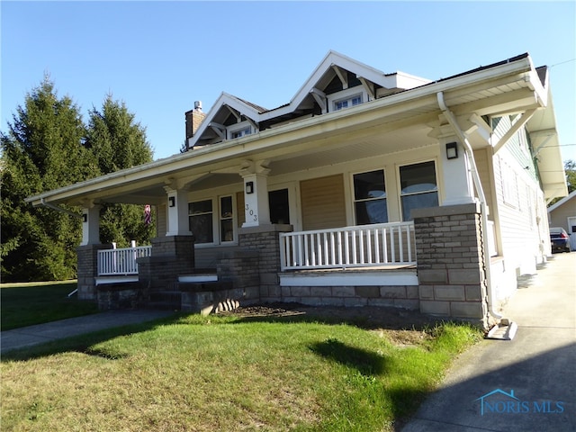 view of front facade featuring a front yard and covered porch