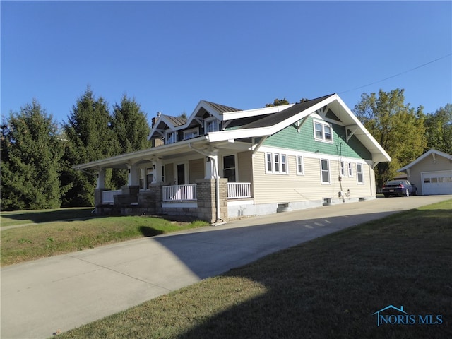 craftsman-style house featuring an outdoor structure, a garage, a porch, and a front lawn