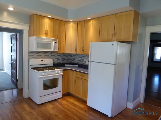 kitchen featuring light brown cabinetry, dark hardwood / wood-style floors, and white appliances