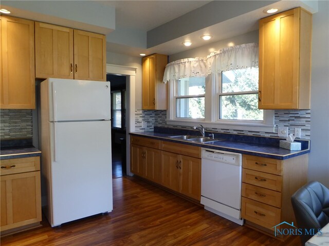 kitchen with dark hardwood / wood-style flooring, tasteful backsplash, sink, and white appliances