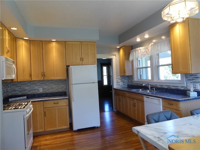 kitchen with dark wood-type flooring, white appliances, a wealth of natural light, and tasteful backsplash