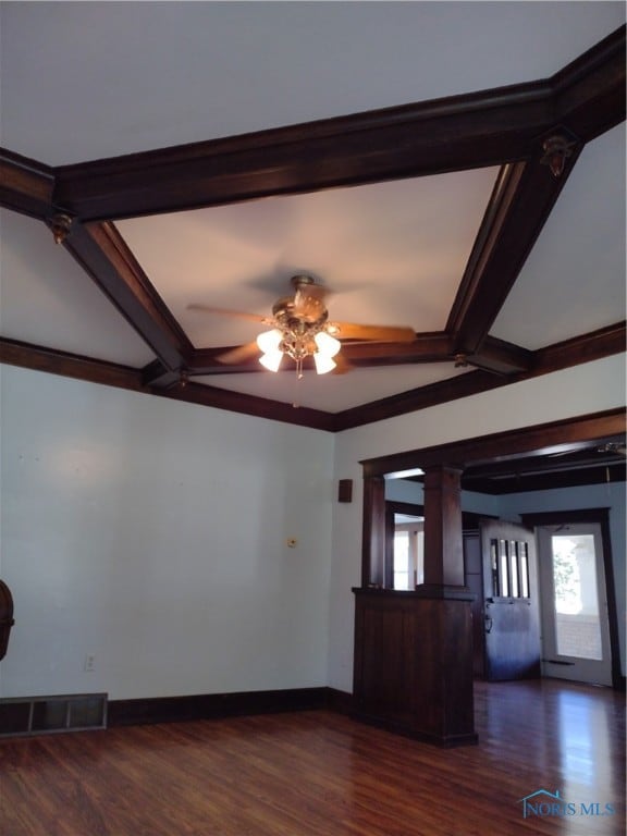 unfurnished living room with ceiling fan, dark hardwood / wood-style floors, beam ceiling, and ornate columns