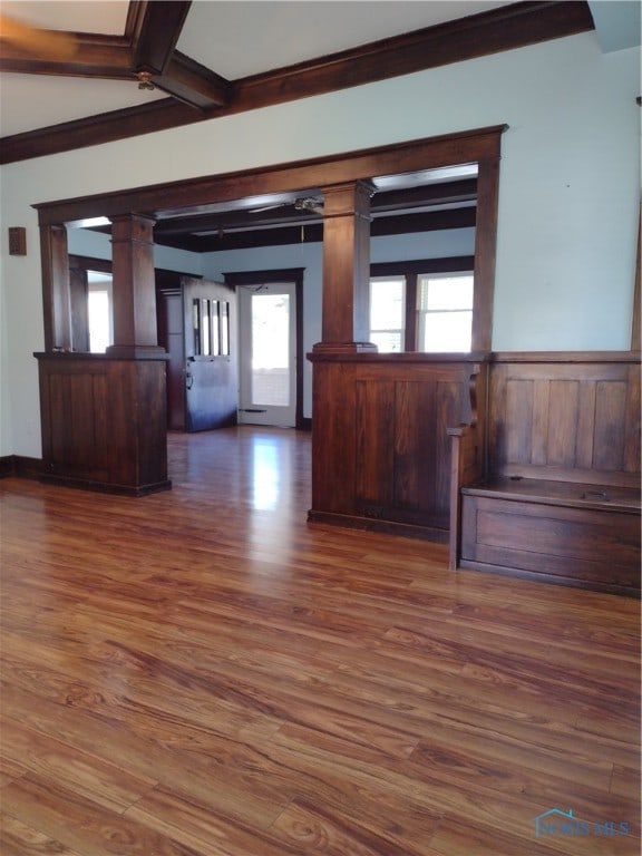 spare room with ornate columns, beamed ceiling, and dark hardwood / wood-style floors