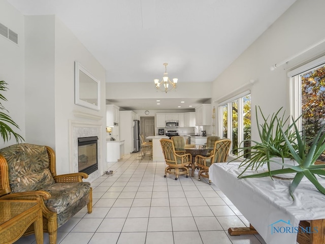 tiled dining area featuring sink, a premium fireplace, and an inviting chandelier