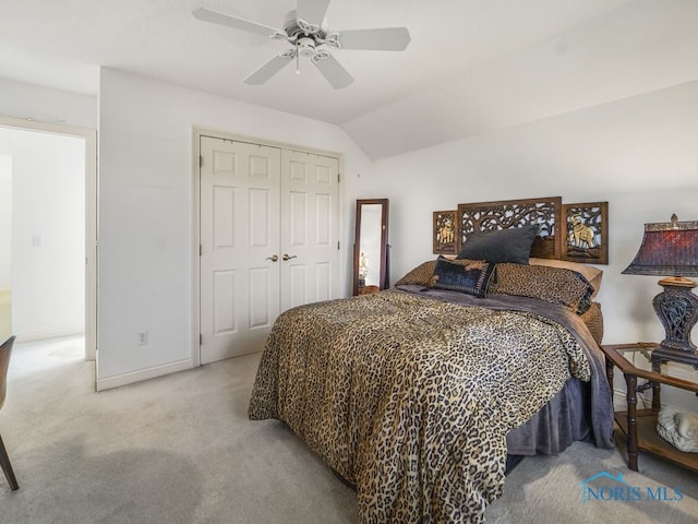 bedroom featuring lofted ceiling, light carpet, a closet, and ceiling fan