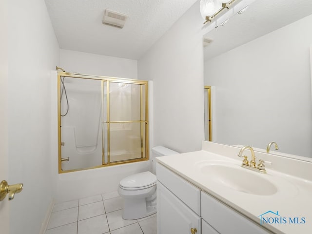 full bathroom featuring combined bath / shower with glass door, a textured ceiling, toilet, vanity, and tile patterned flooring