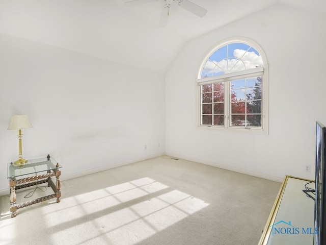 carpeted spare room with vaulted ceiling and ceiling fan