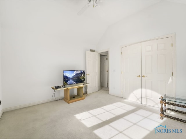 carpeted bedroom with vaulted ceiling, a closet, and ceiling fan