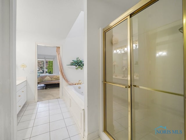 bathroom featuring vanity, vaulted ceiling, shower with separate bathtub, and tile patterned flooring