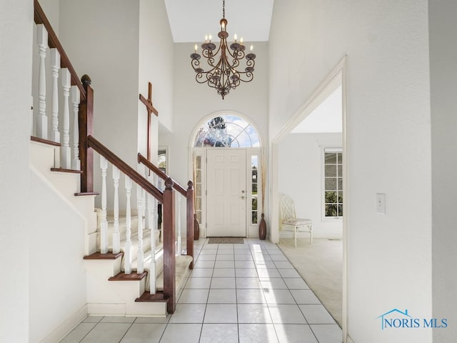 entryway with light carpet, a high ceiling, and a chandelier