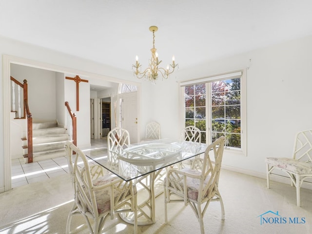 carpeted dining space featuring a chandelier