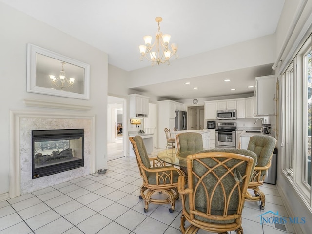 tiled dining space with sink, a chandelier, and a high end fireplace