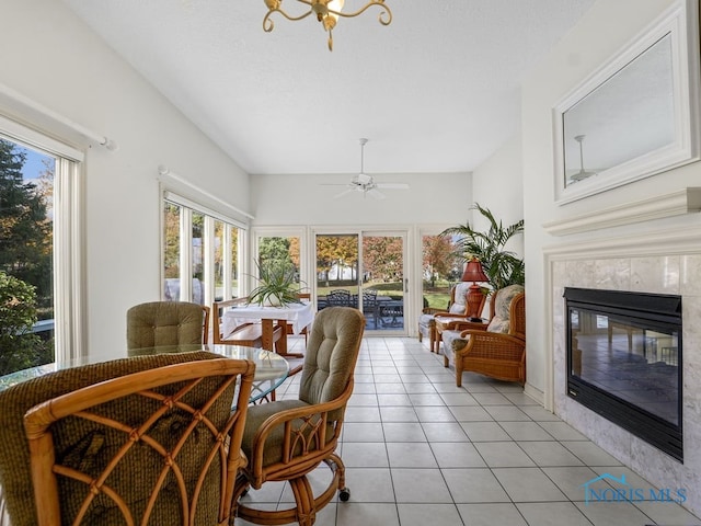 sunroom / solarium with a wealth of natural light, a premium fireplace, and ceiling fan