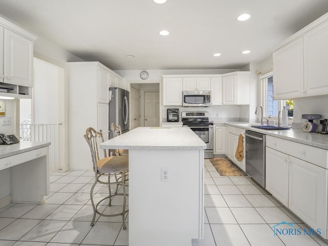 kitchen featuring appliances with stainless steel finishes, a kitchen bar, a kitchen island, and white cabinets