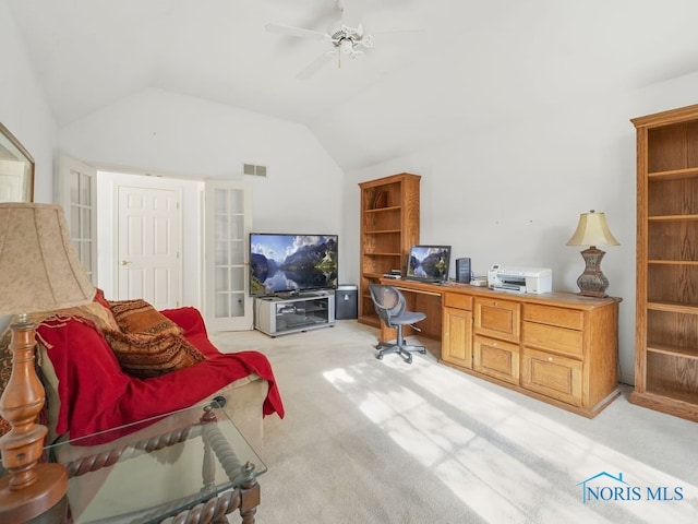 office space with built in desk, vaulted ceiling, light carpet, and ceiling fan