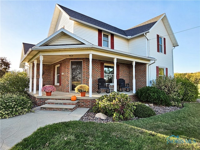 view of front of property with a porch and a front yard