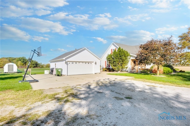 view of side of property with a storage shed, a yard, and a garage