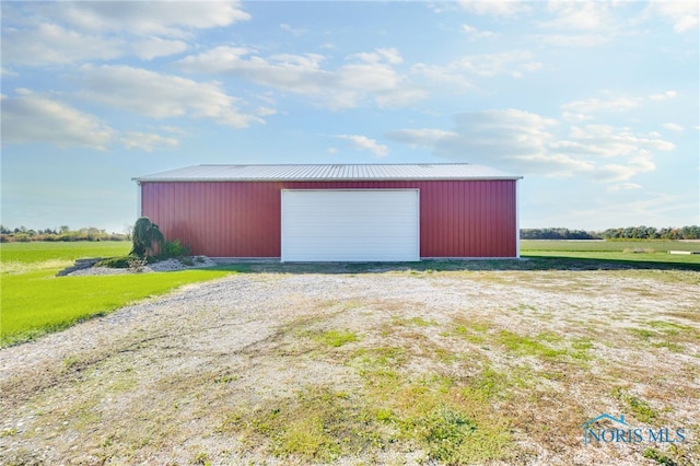 view of outdoor structure featuring a garage and a rural view