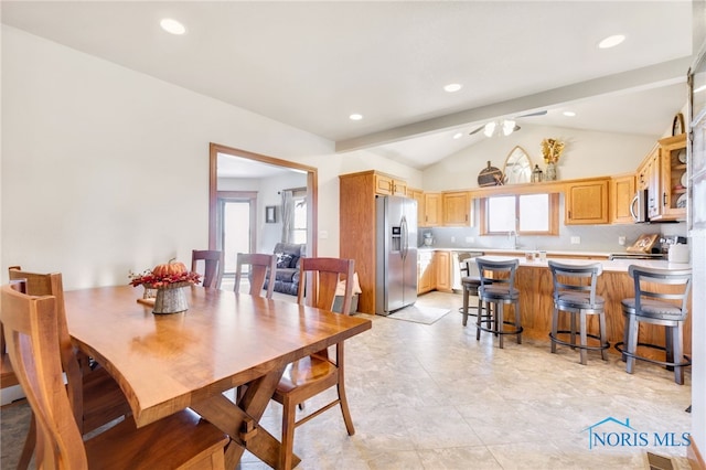 tiled dining space with lofted ceiling with beams, sink, and ceiling fan