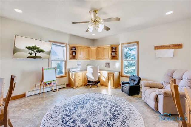 sitting room featuring built in desk, ceiling fan, a baseboard radiator, and plenty of natural light