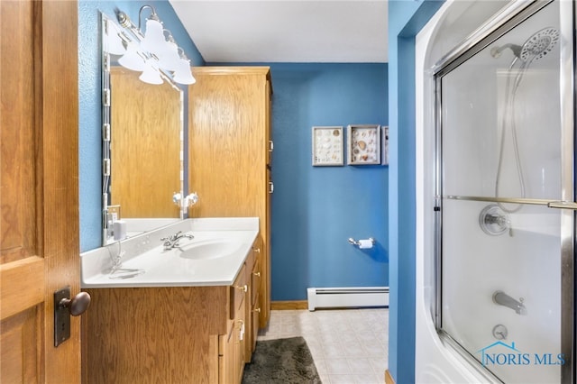 bathroom with vanity, enclosed tub / shower combo, and a baseboard heating unit