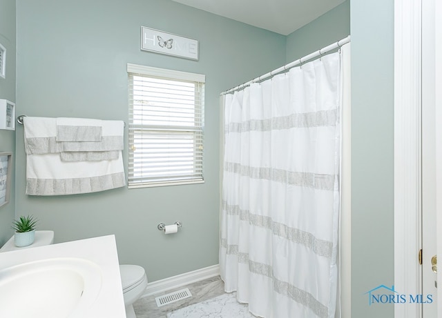 bathroom featuring walk in shower, vanity, and toilet