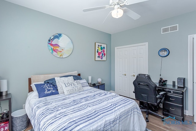 bedroom featuring hardwood / wood-style floors, ceiling fan, and a closet