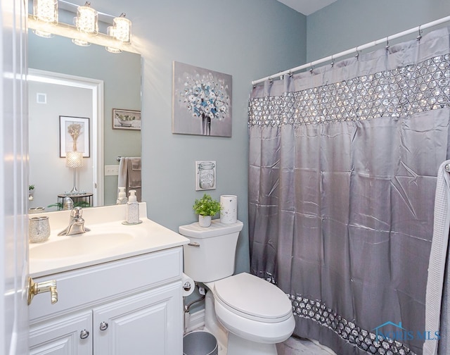 bathroom featuring a shower with curtain, vanity, and toilet