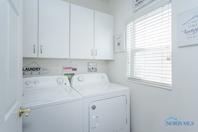 clothes washing area featuring plenty of natural light, independent washer and dryer, and cabinets