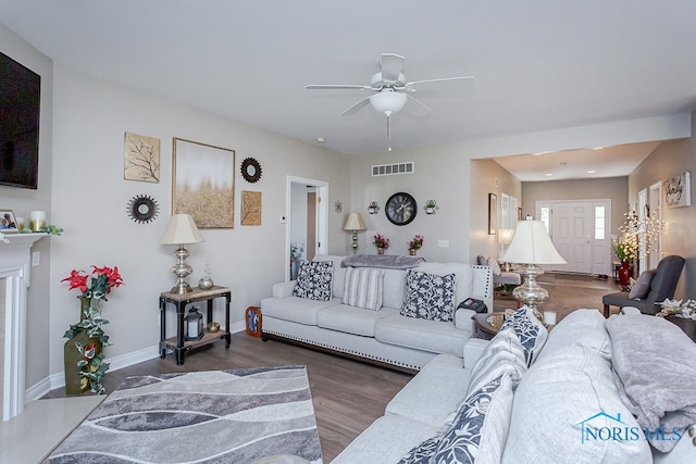 living room featuring ceiling fan and dark wood-type flooring