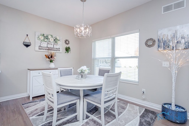 dining space featuring hardwood / wood-style floors and a chandelier