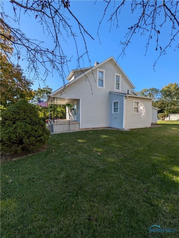 back of house with a lawn and a patio area