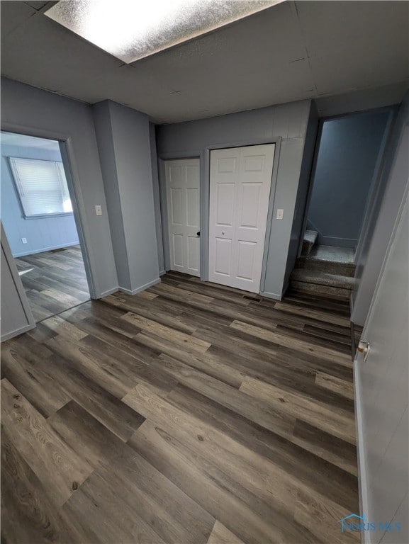 unfurnished bedroom featuring a closet and dark hardwood / wood-style flooring