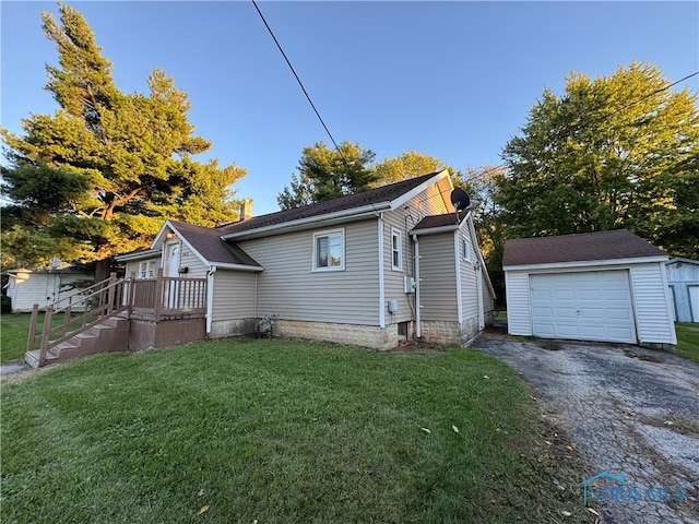 view of home's exterior featuring a garage, a yard, and an outbuilding