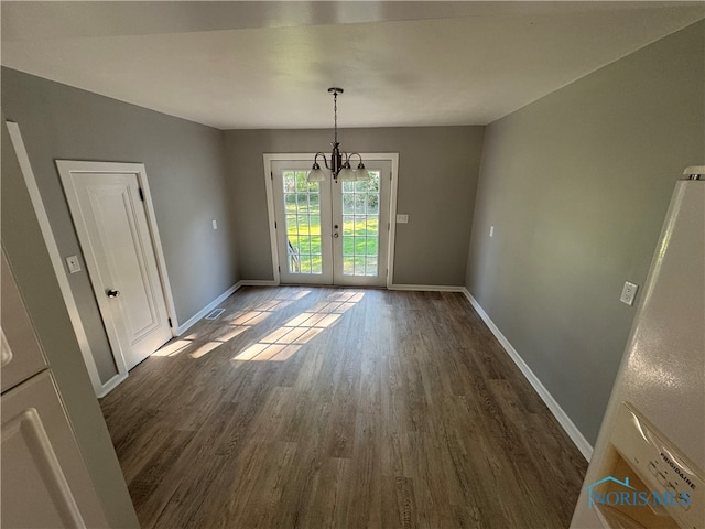 interior space featuring hardwood / wood-style flooring, lofted ceiling, french doors, and an inviting chandelier