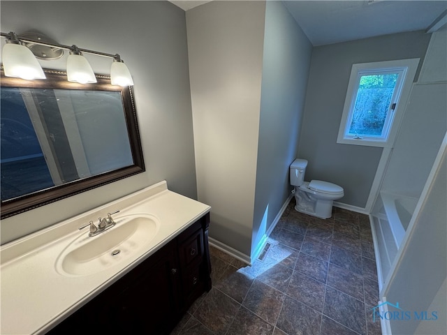 bathroom with a bath, vanity, and toilet