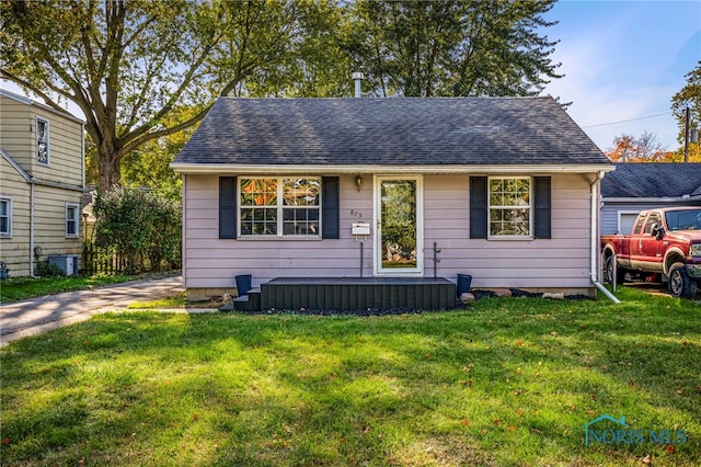 view of front facade featuring a front lawn and central AC unit