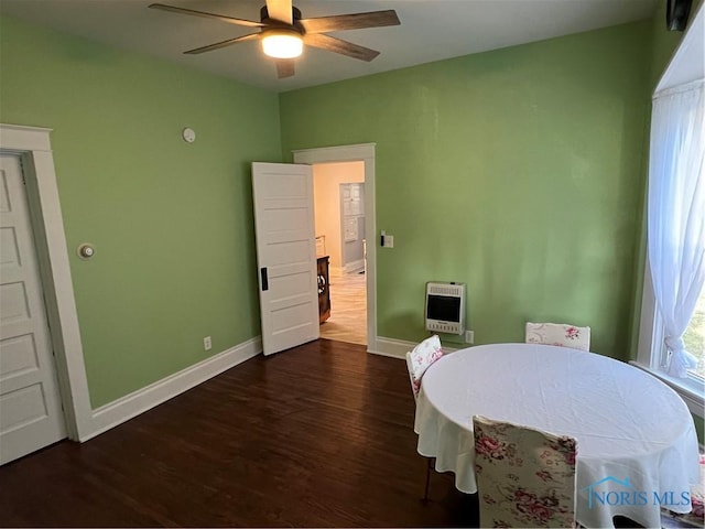 dining area featuring dark hardwood / wood-style flooring, heating unit, and ceiling fan