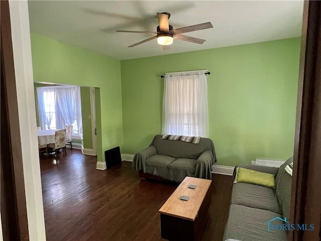 living room featuring ceiling fan and dark hardwood / wood-style flooring