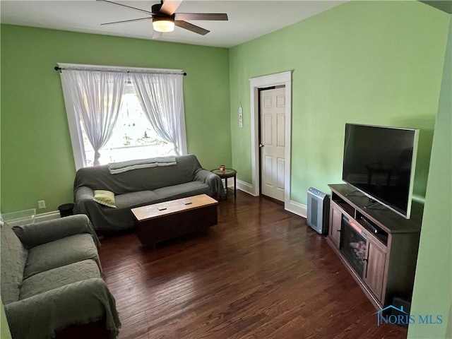 living room featuring ceiling fan and dark wood-type flooring